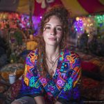 Alternative looking hippy style woman seated wearing an Alex Tooth Inner Flight Ritual Wrap shawl cover up.