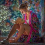 Hippy woman by water fountain sitting reading a book wearing Alex Tooth Radiant Bloom MoonFlow Kimono robe.