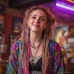 Hippy woman in boho cafe with tattoos wearing Alex Tooth Radiant Bloom MoonFlow Kimono robe.