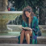 Hippy woman by water fountain sitting reading a book wearing Alex Tooth Emerald StarGate MoonFlow Kimono robe.