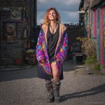 Alternative hippy boho style woman standing outside wearing buckle up fleece lined Alex Tooth Inner Flight Vision Robe.