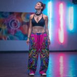Alternative looking hippy style woman inside a yoga studio wearing Alex Tooth Radiant Bloom FlowState Pants.