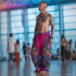 Alternative looking hippy style man inside a yoga studio wearing Alex Tooth Radiant Bloom FlowState Pants.