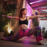 Alternative looking hippy style woman inside a yoga studio wearing Alex Tooth Radiant Bloom FlowState Pants.