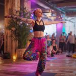 Alternative looking hippy style woman inside a yoga studio wearing Alex Tooth Radiant Bloom FlowState Pants.
