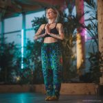 Alternative looking hippy style woman inside a yoga studio wearing Alex Tooth Emerald StarGate FlowState Pants.