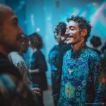 Smart looking alternative hippy style man standing in a inside social function setting wearing an Alex Tooth Emerald StarGate InnerLight Shirt.