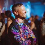 Smart looking alternative hippy style man standing in a inside social function setting wearing an Alex Tooth Inner Flight InnerLight Shirt.