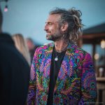 Alternative edgy looking hippy man standing looking cool wearing an Alex Tooth Radiant Bloom Wayfarer Blazer.