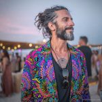 Alternative edgy looking hippy man standing looking cool wearing an Alex Tooth Radiant Bloom Wayfarer Blazer.