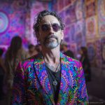 Alternative edgy looking hippy man standing looking cool wearing an Alex Tooth Radiant Bloom Wayfarer Blazer.