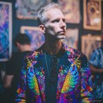 Alternative edgy looking hippy man standing looking cool wearing an Alex Tooth Inner Light Wayfarer Blazer.