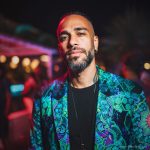 Alternative edgy looking hippy man standing looking cool wearing an Alex Tooth Emerald StarGate Wayfarer Blazer.