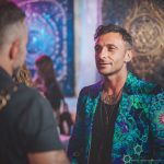 Alternative edgy looking hippy man standing looking cool wearing an Alex Tooth Emerald StarGate Wayfarer Blazer.