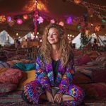 Alternative looking hippy woman sitting outside smiling, wearing long zip up fleece lined Alex Tooth Inner Flight Ritual Robe