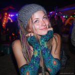 Alternative looking hippy style woman smiling, wearing Alex Tooth Emerald StarGate Aurasleeve Gloves.