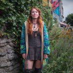 Alternative looking hippy woman standing outside wearing long zip up fleece lined Alex Tooth Emerald StarGate Ritual Robe