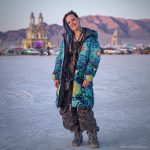 Alternative looking hippy style woman in a winter season outdoor setting wearing an Alex Tooth Emerald StarGate Nomad Coat Long Puffer Winter Coat.