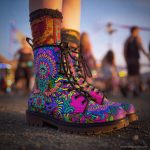 A pair of combat boots at a music festival, the boots are Alex Tooth Radiant Bloom Spirit Boots.