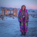 Alternative looking hippy style woman in a winter season outdoor setting wearing an Alex Tooth Radiant Bloom Nomad Coat Long Puffer Winter Coat.