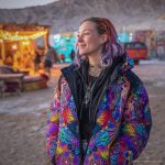 Alternative looking hippy style woman in a winter season outdoor setting wearing an Alex Tooth Inner Flight Nomad Coat Long Puffer Winter Coat.